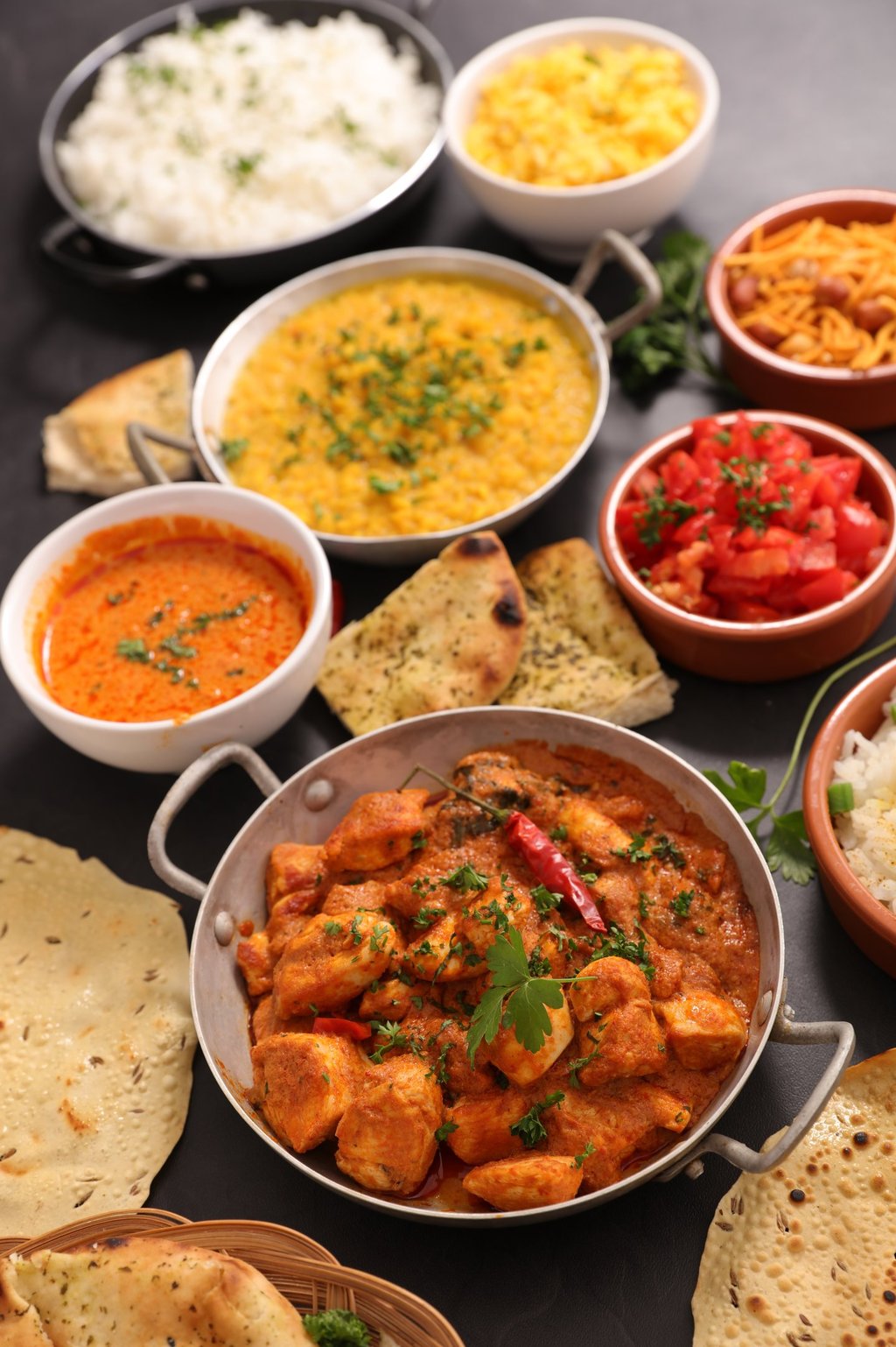 Indian vegetarian meal with paneer curry, naan bread, rice, dal, and traditional side dishes