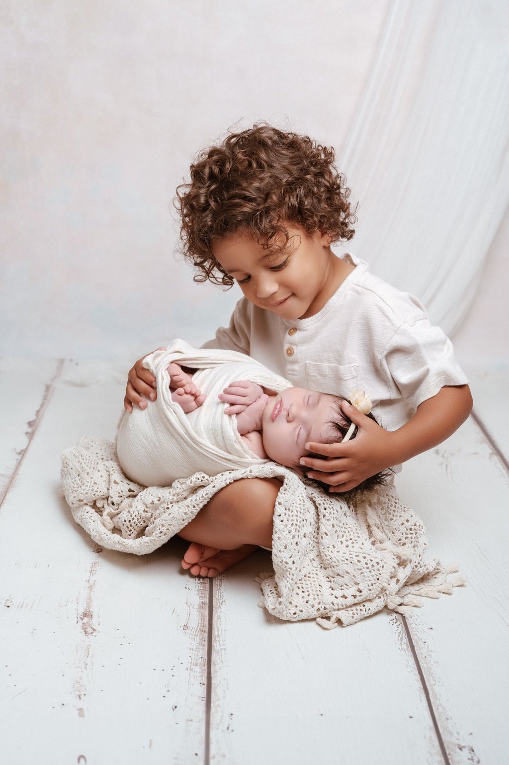a young child is holding a newborn baby