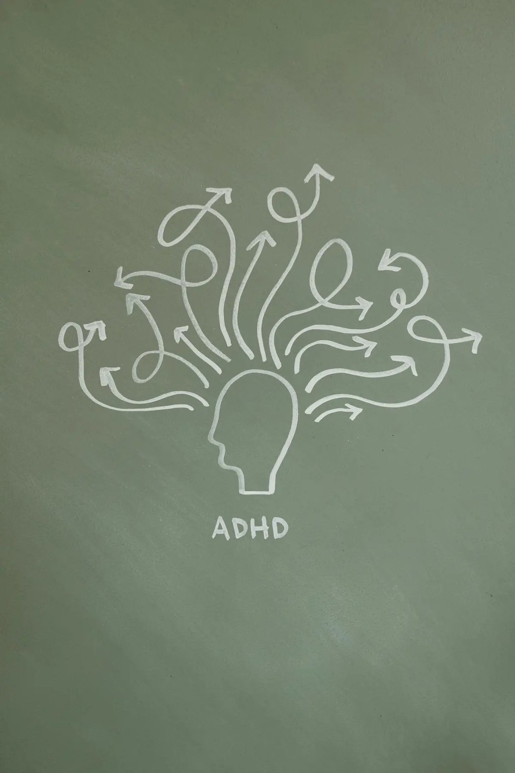 Chalk drawing of a human head with tangled arrows representing ADHD brain activity and focus.