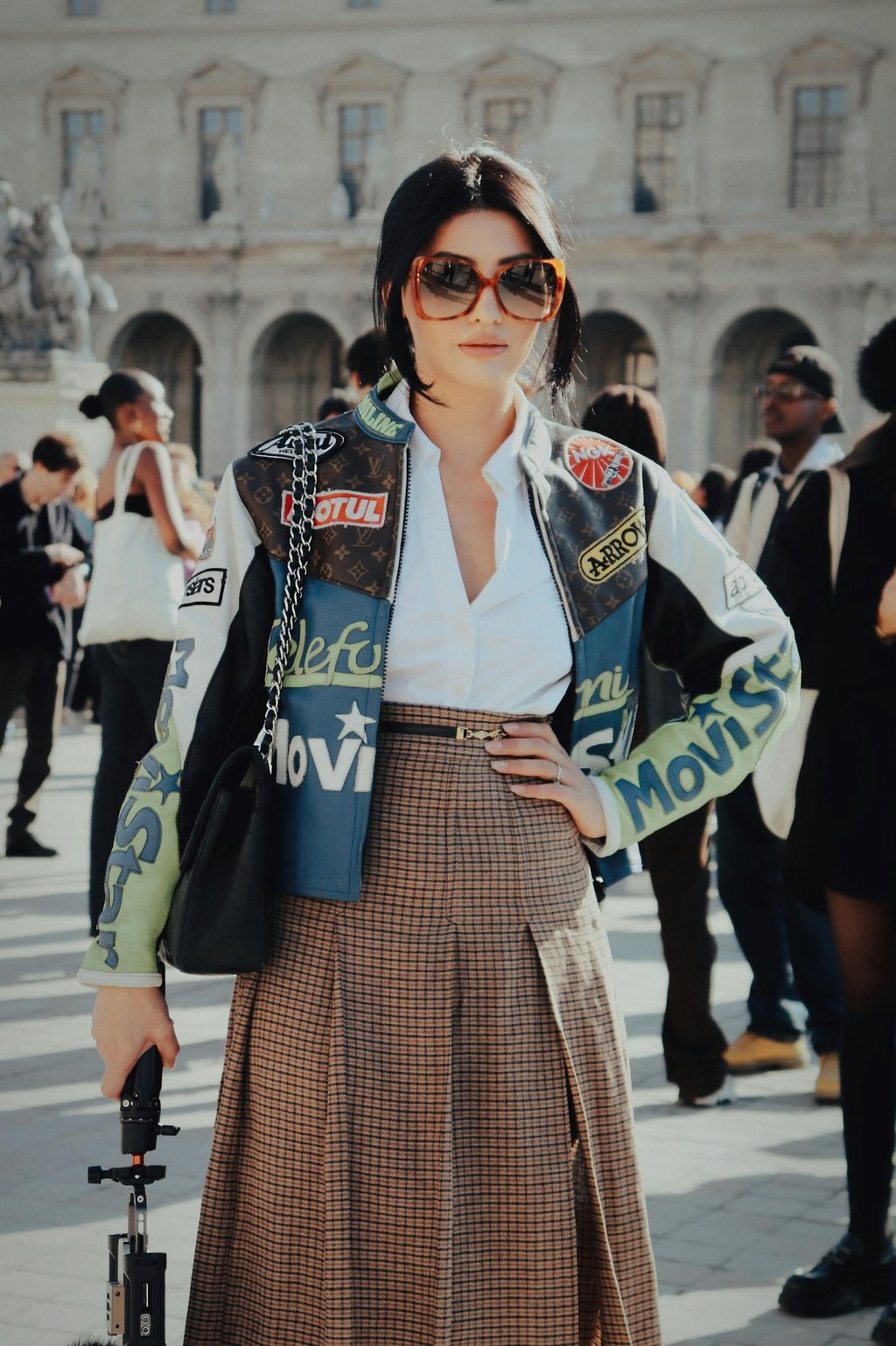 une femme à la fashion week qui porte une verte en cuir avec des patchs