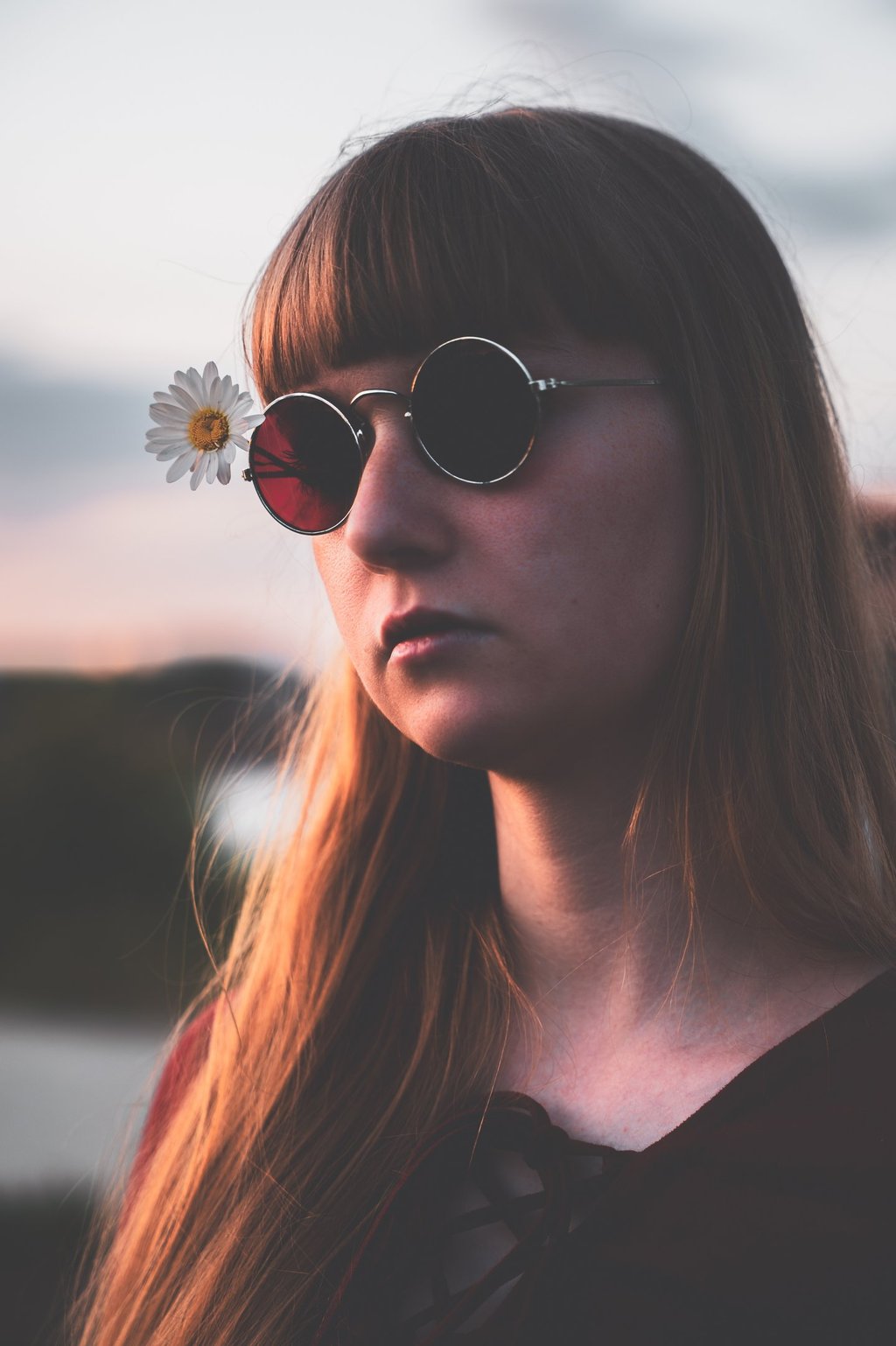 a woman with sunglasses on her face during sunset