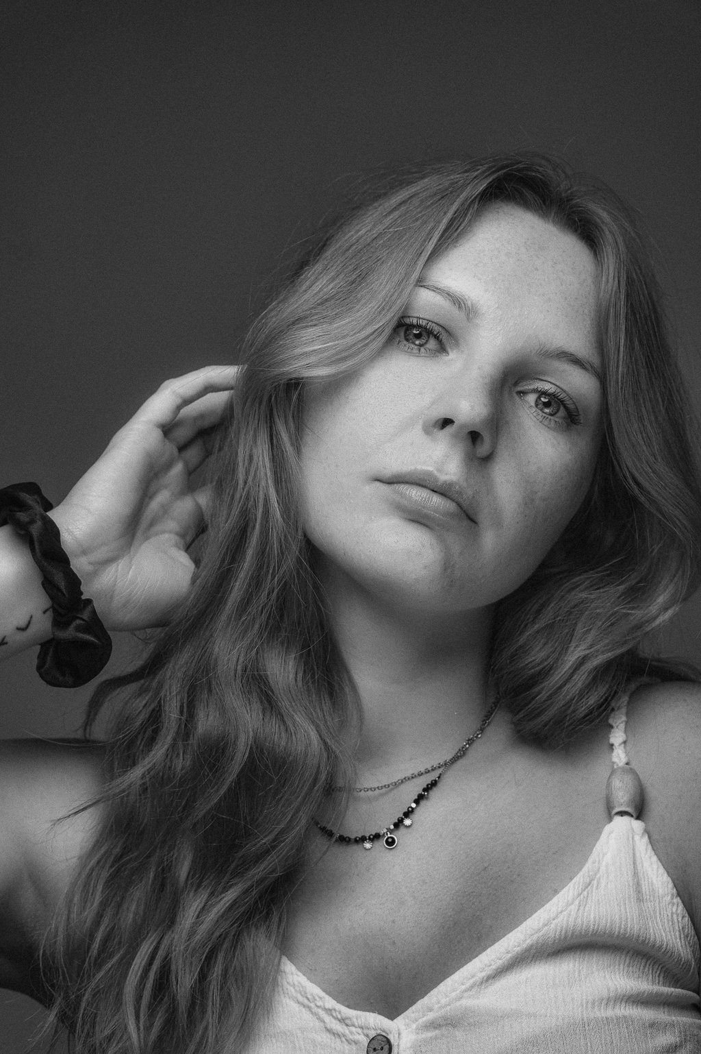 zwart-wit portret van vrouw met golvend haar en sieraden