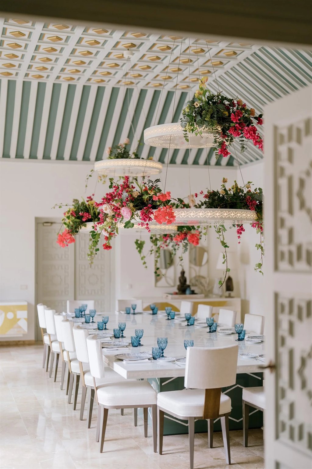 Grand dining room with floral chandeliers and patterned vaulted ceiling