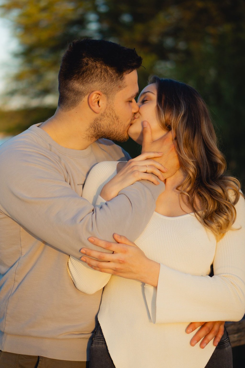 Paar küsst sich innig im goldenen Sonnenlicht am See. Romantisches Verlobungsfoto: Just Perspectives.