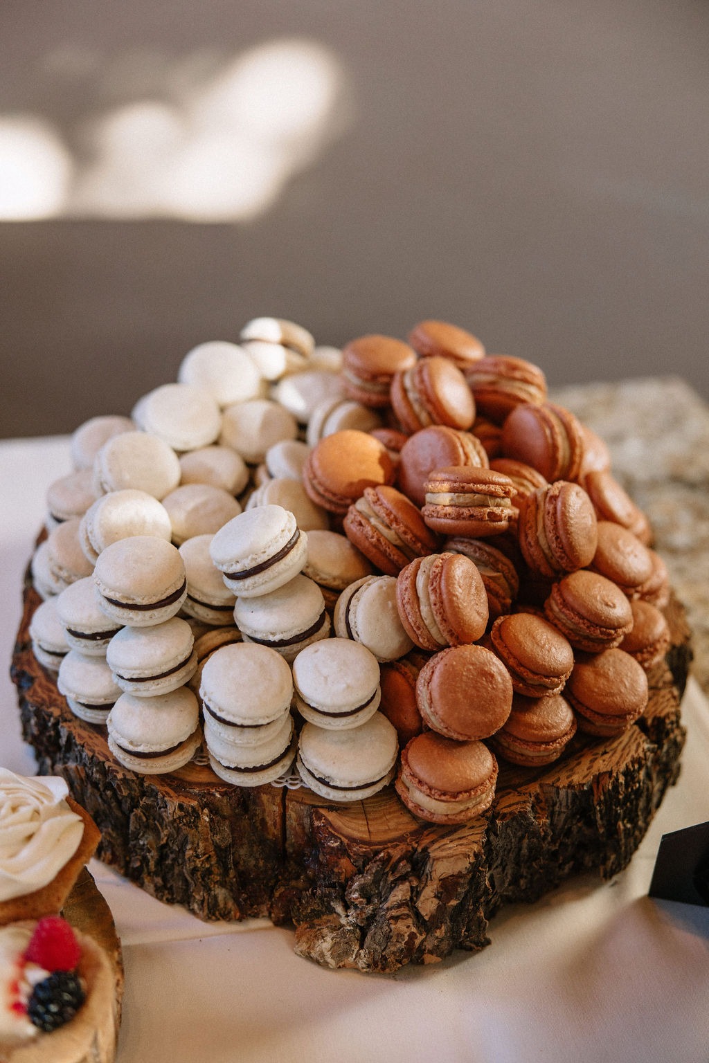 A pile of macarons shown as part of a luxury wedding dessert table