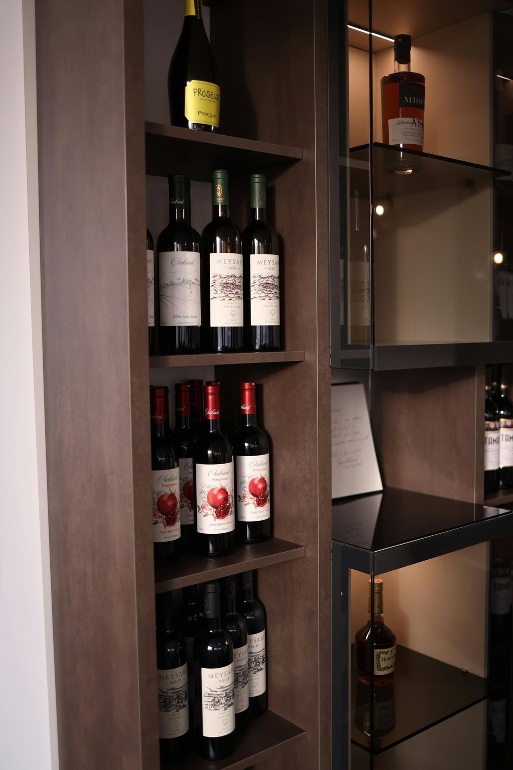 Modern luxury wine display with custom wood joinery and premium ambient lighting.