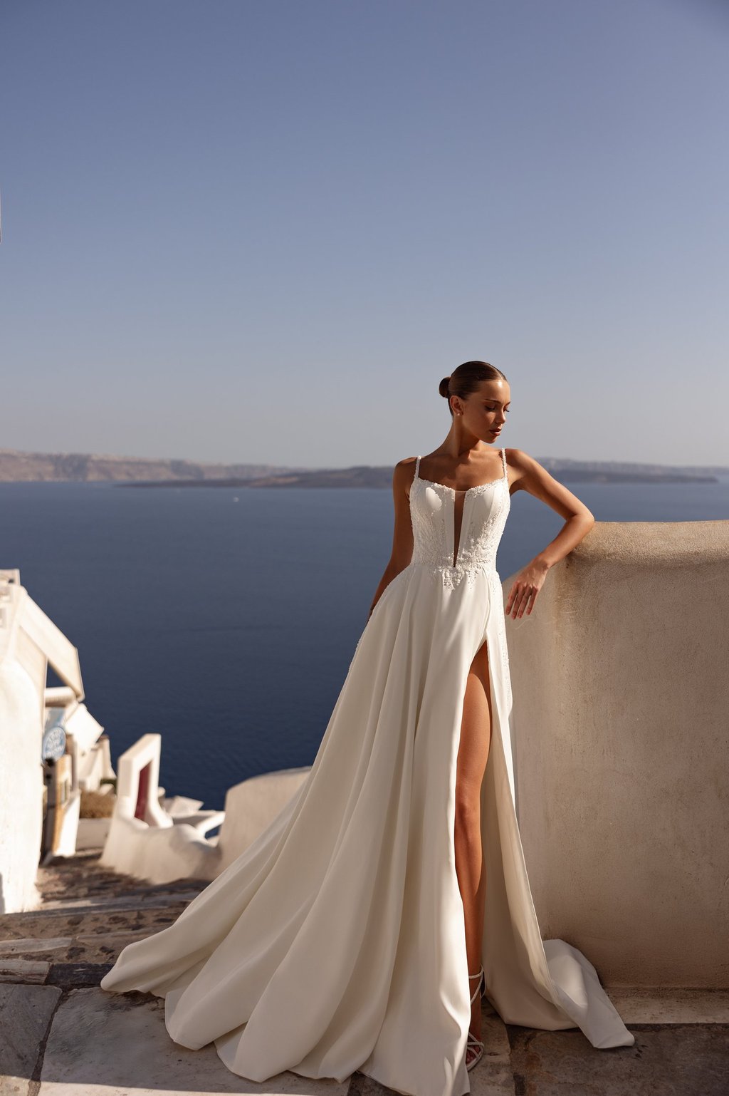 a woman in a white dress standing on a balcony