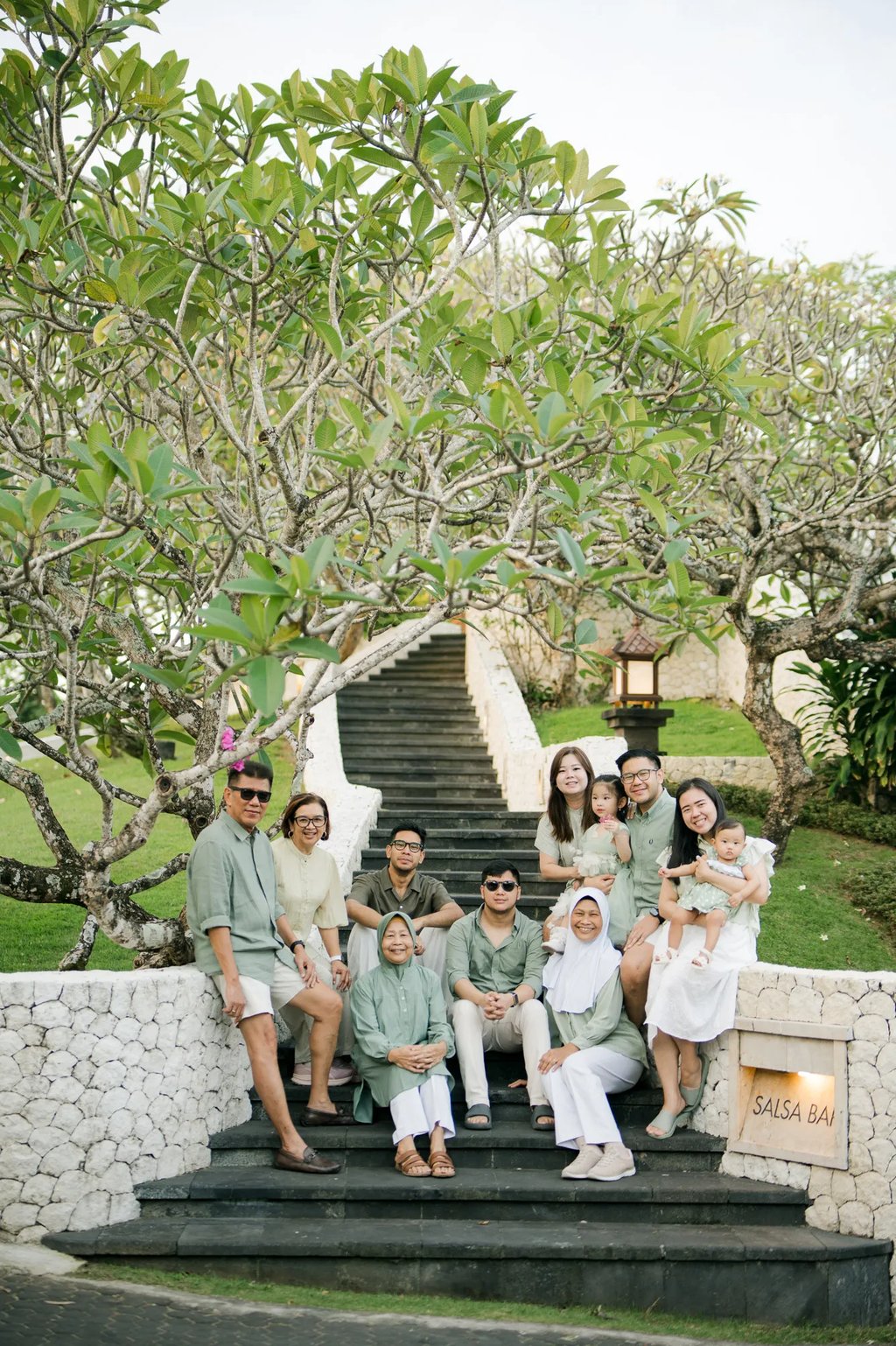 Three generation family posing together in a tropical garden during a family photography session in Bali.