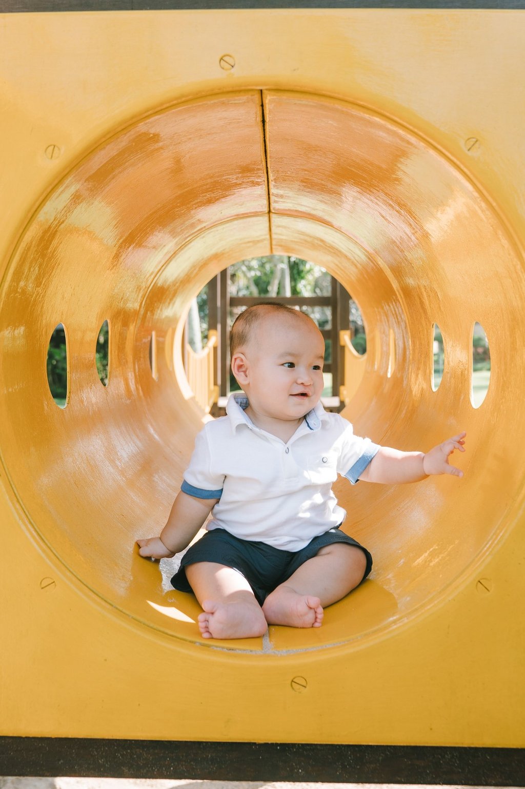 Baby sitting inside playground slide at Intercontinental Jimbaran during a natural lifestyle family photography session
