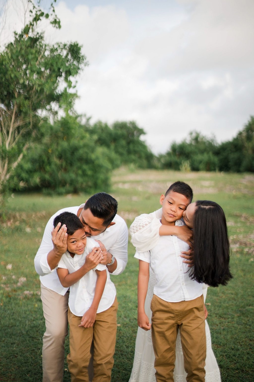 Intimate moment of Ayunda family embracing at Melasti Beach Bali.