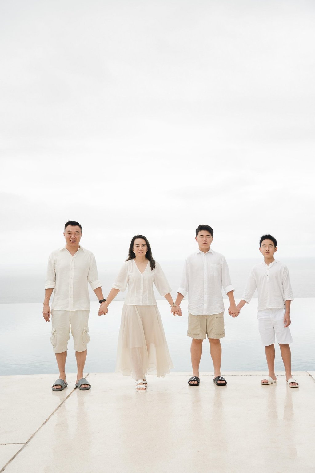 Family standing in minimal ocean view composition at Alila Villas Uluwatu Bali with clean horizon