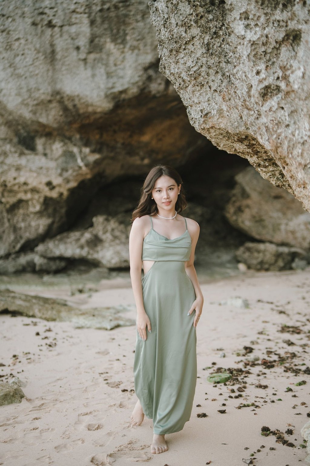 Portrait of woman standing near cave rock formation at Geger Beach Nusa Dua Bali