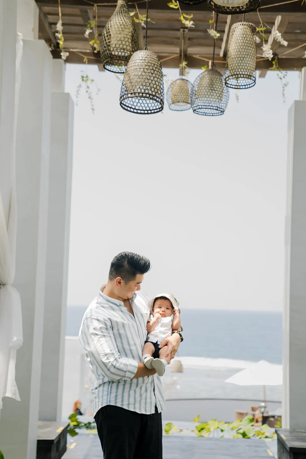 Father holding his baby during a family photography session at Samabe Bali Suites & Villas in Nusa Dua.