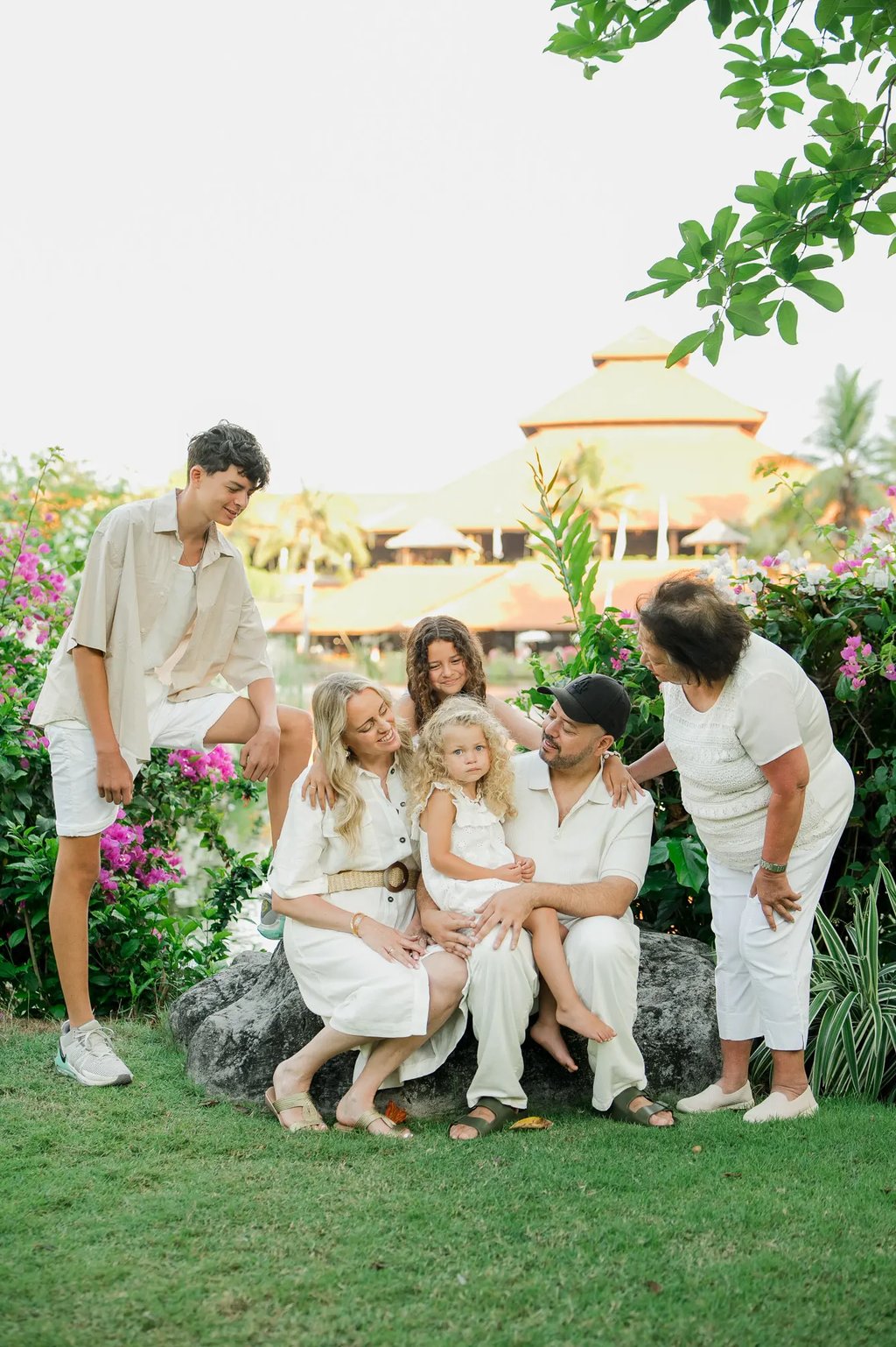 Family portrait surrounded by tropical gardens during a photography session at Ayodya Resort Bali in Nusa Dua