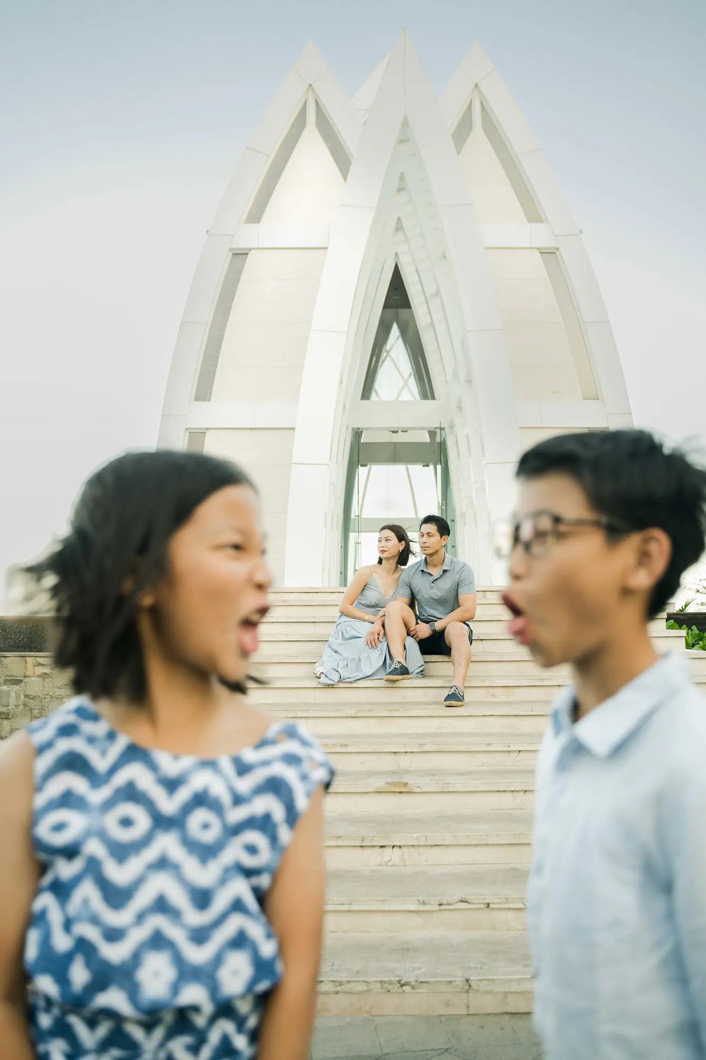 Family standing in front of the iconic chapel during a luxury family photography session at The Ritz-Carlton Bali.