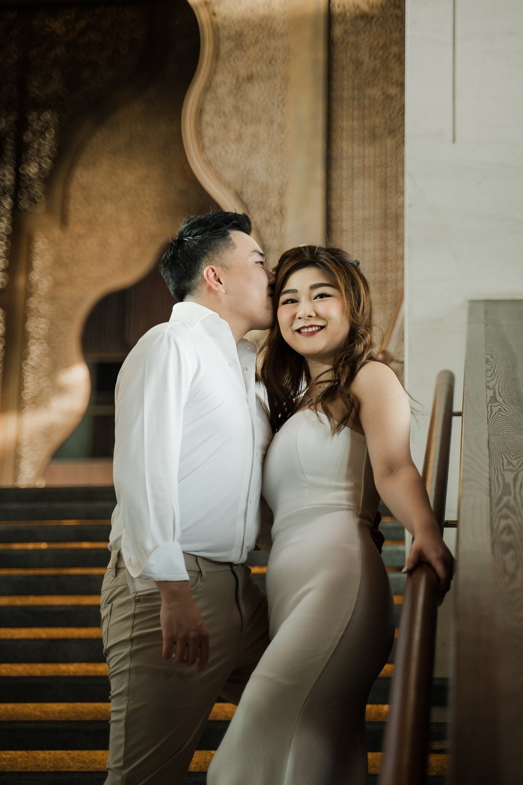 Elegant couple portrait on the grand staircase during a romantic prewedding session at Apurva Kempinski Bali