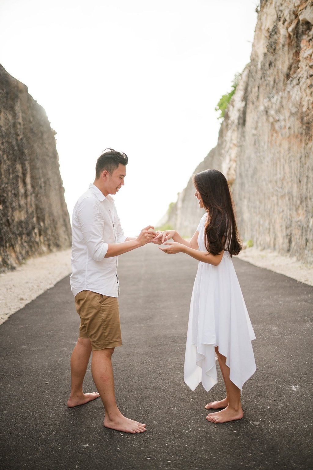 Proposal moment on a cliff road at Melasti Beach Bali with couple standing together