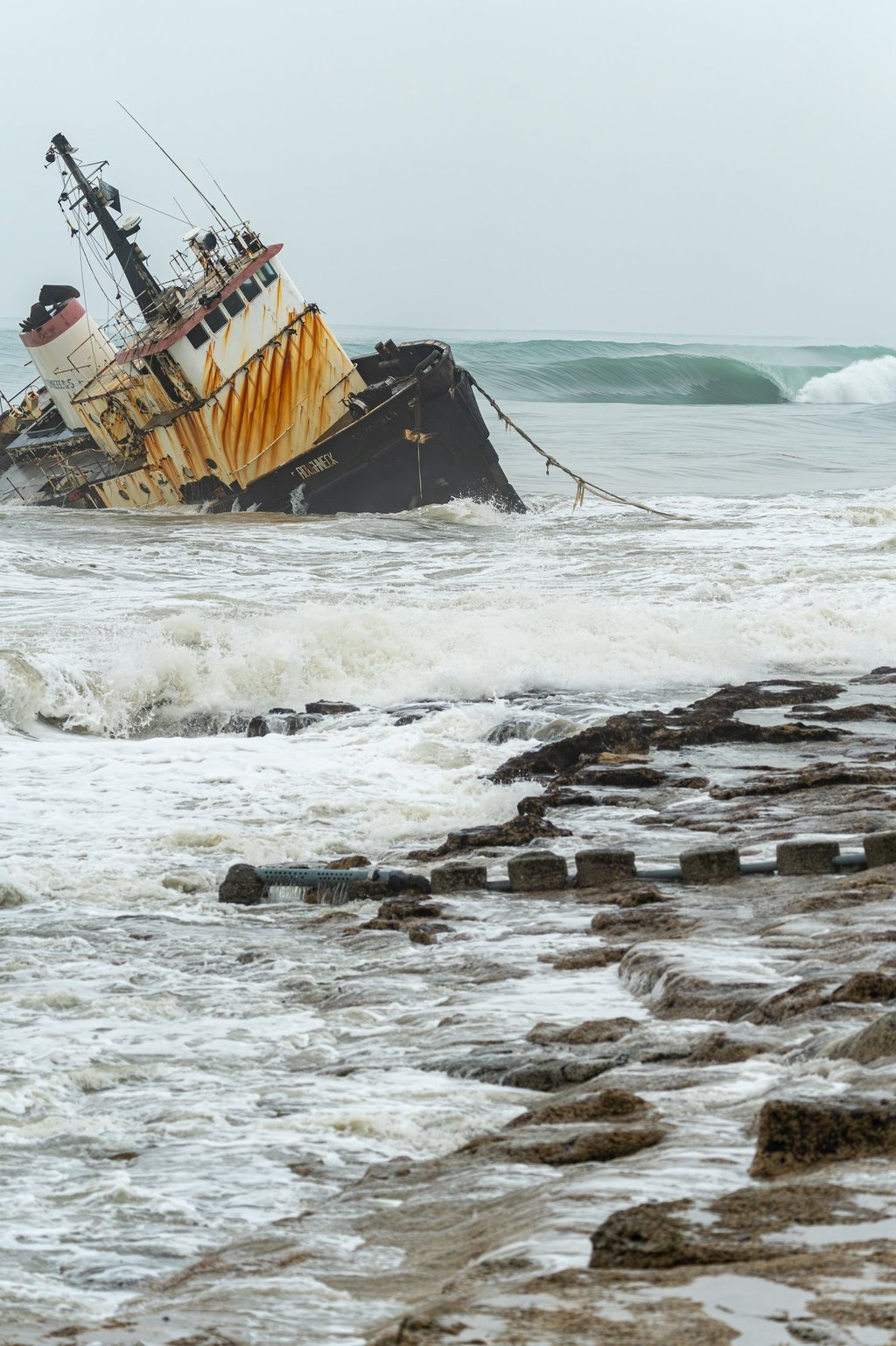 Shipwreck with perfect wave rolling on the back