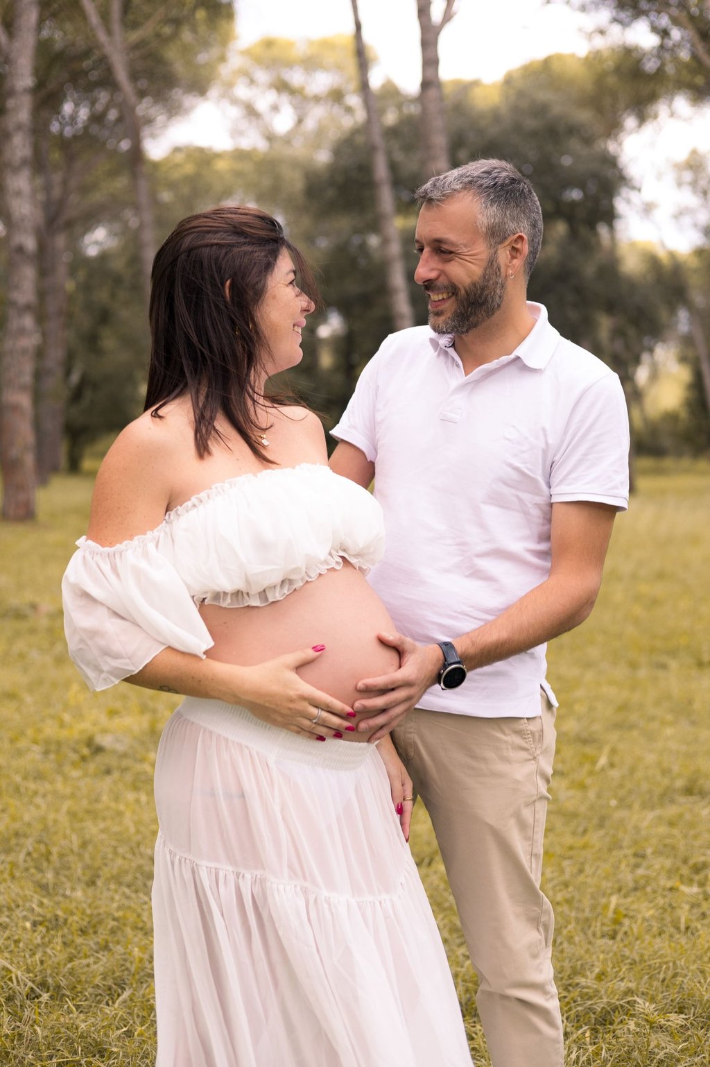 Sessió de fotos d'embaràs d'una parella amb dona embarassada en entorn natural exterior