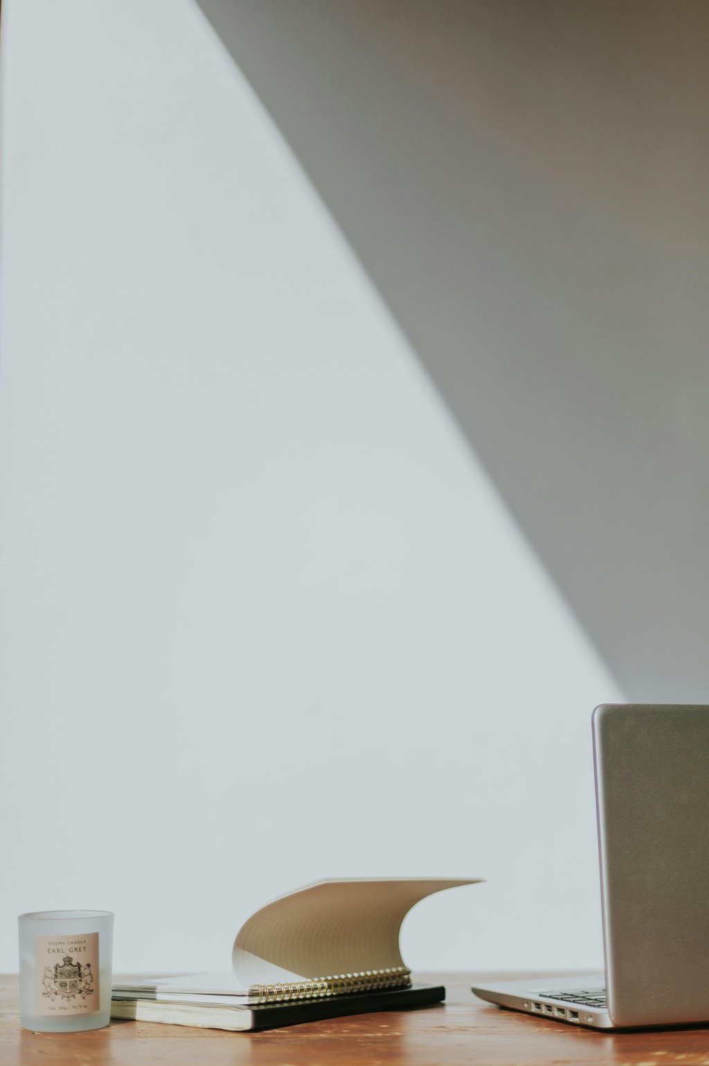 A notebook blowing open towards a laptop.