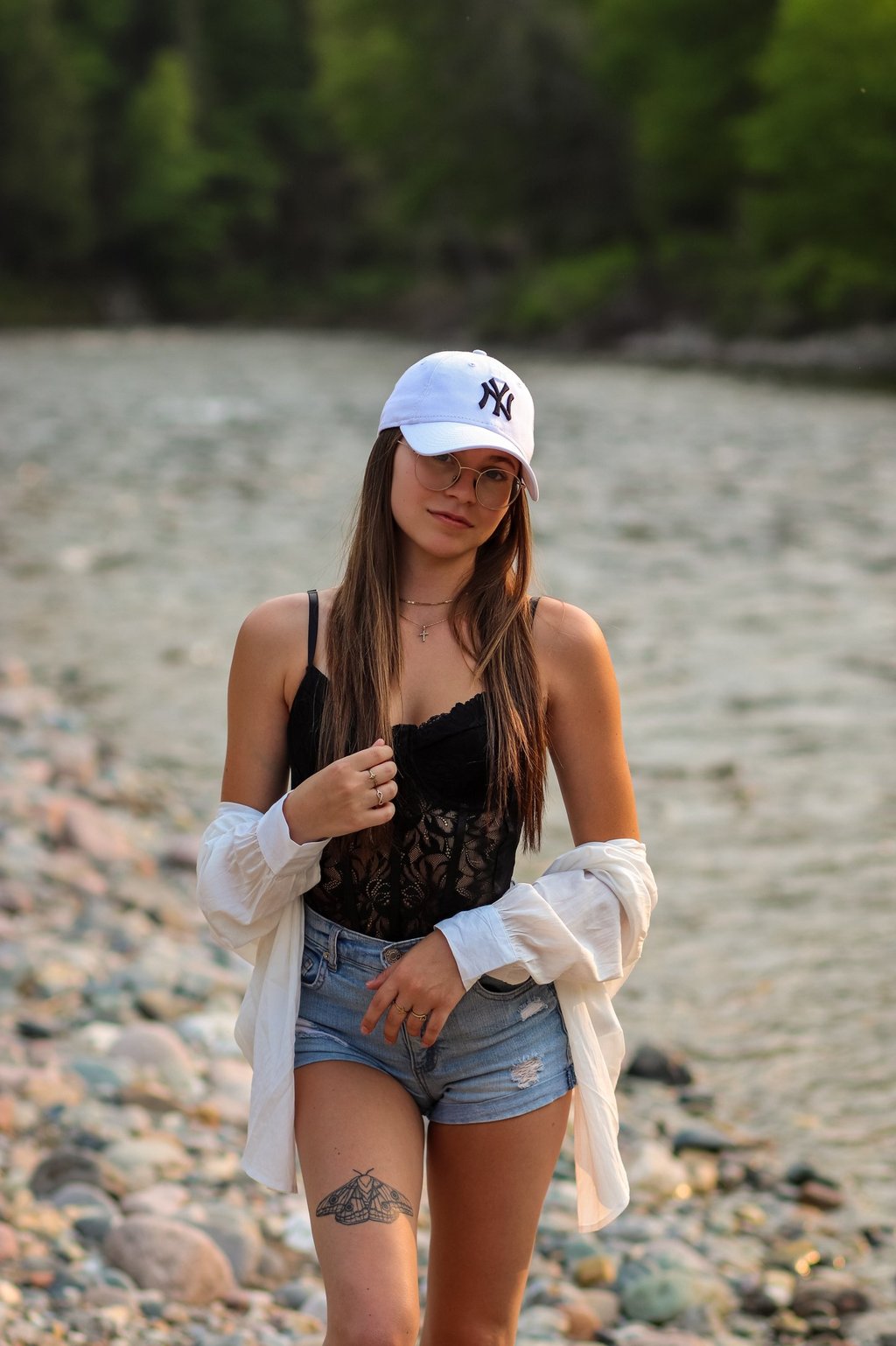 alyssacestmoii avec un haut noir et short avec une casquette blanche