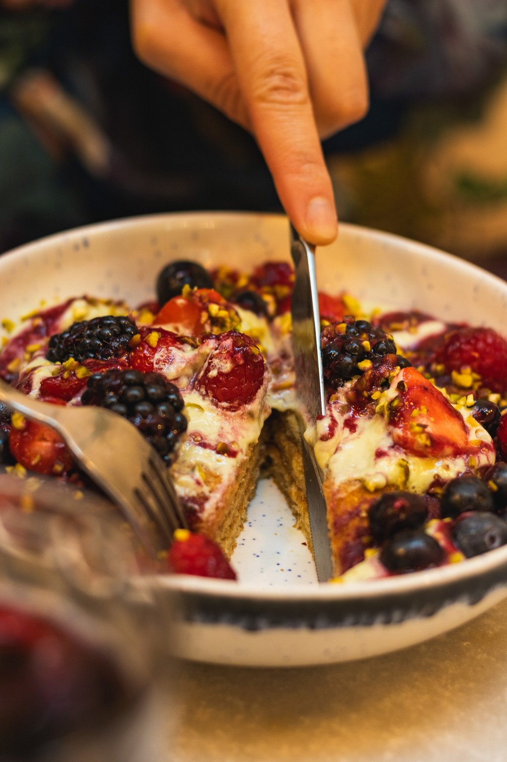 a person cutting into slices of fruit on a plate