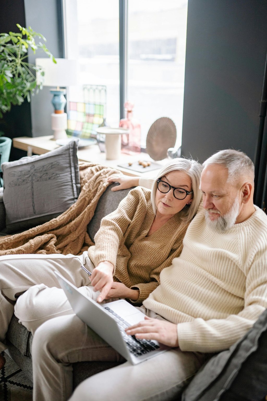 A woman and a man are looking at a laptop