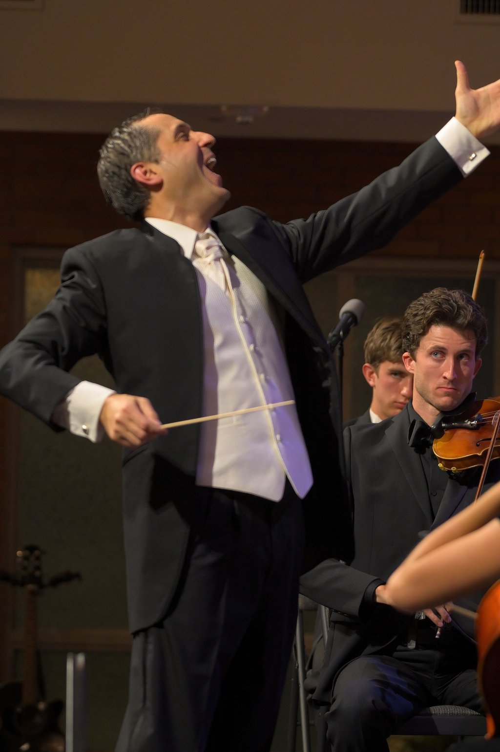 A joyful picture of Leandro conducting orchestra and choir