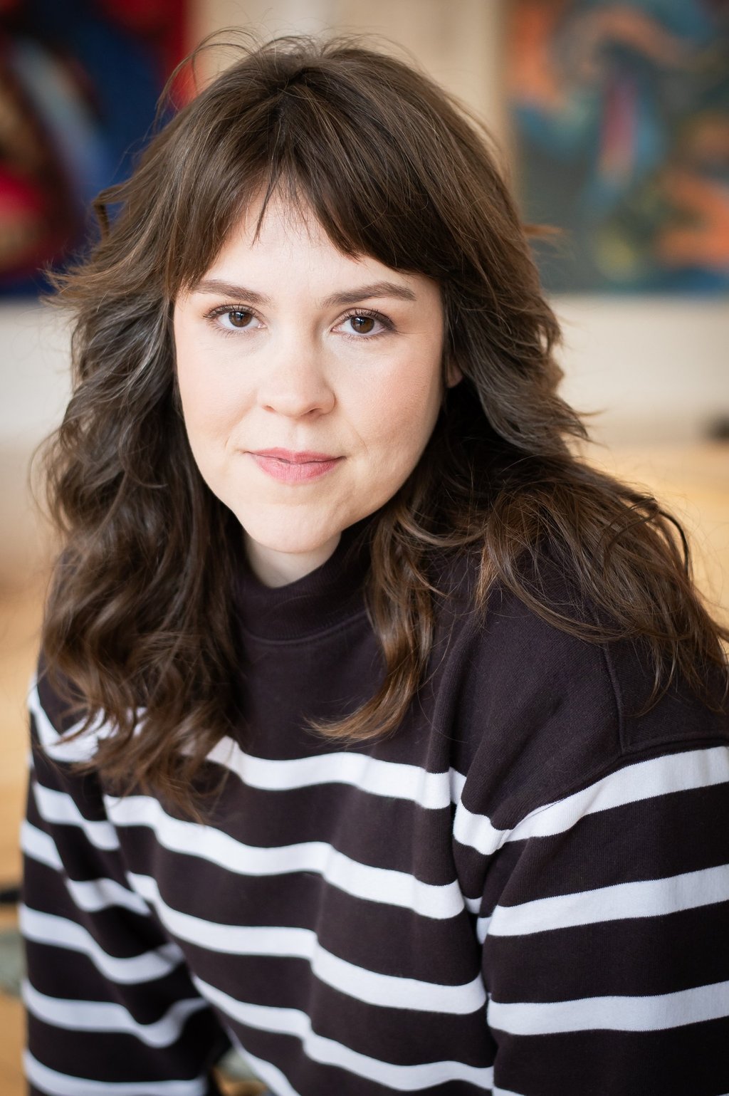 Headshot of young woman wearing a striped sweater.