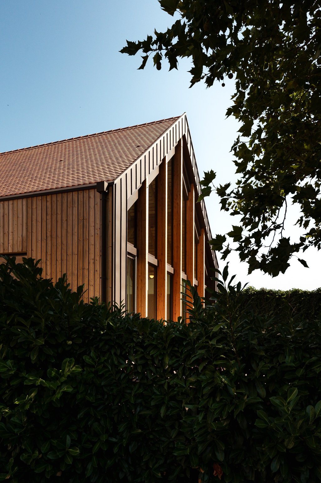 a building with a clock towering over a hedge
