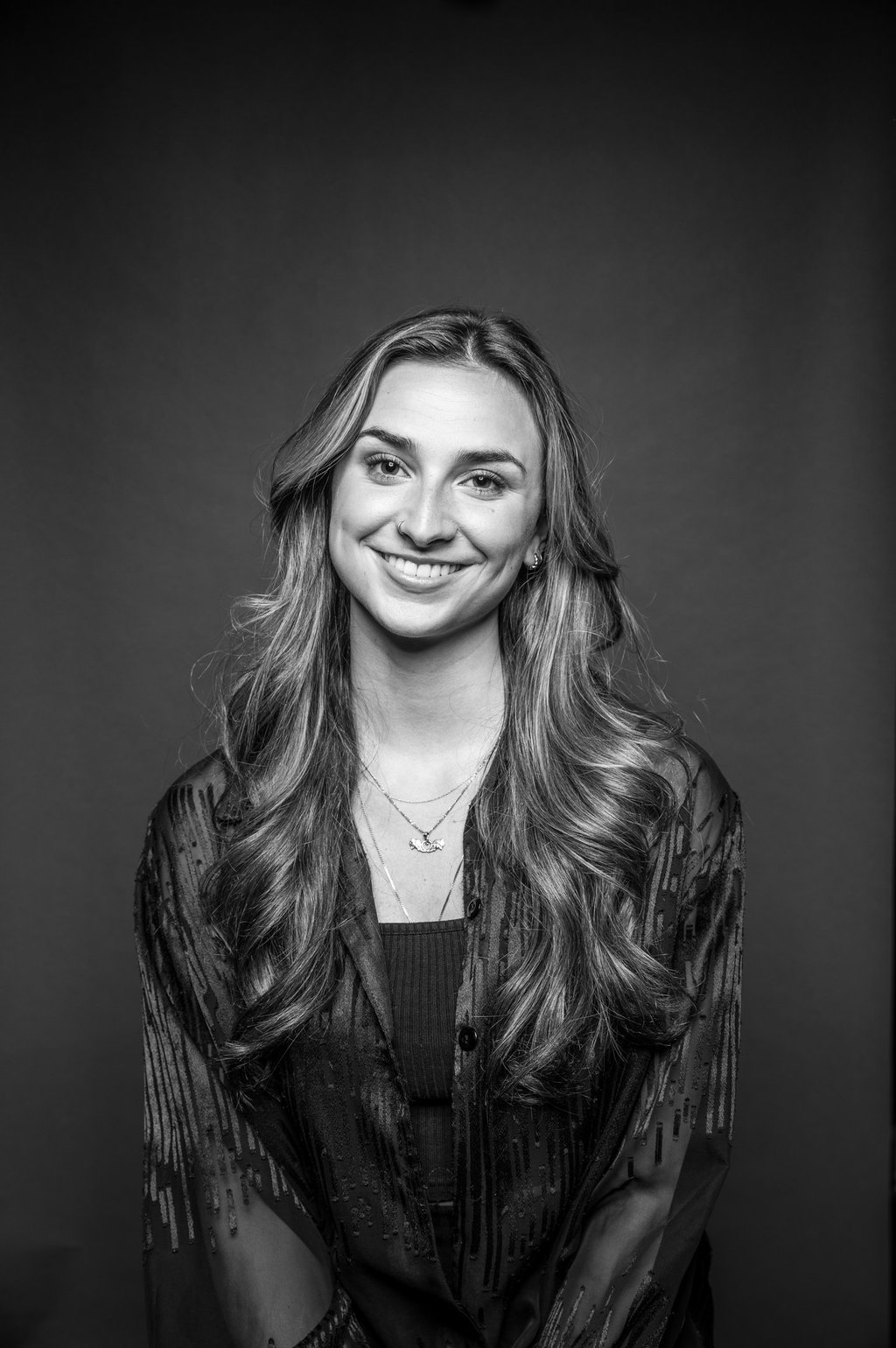 Marilou, a smiling makeup artist in black and white.