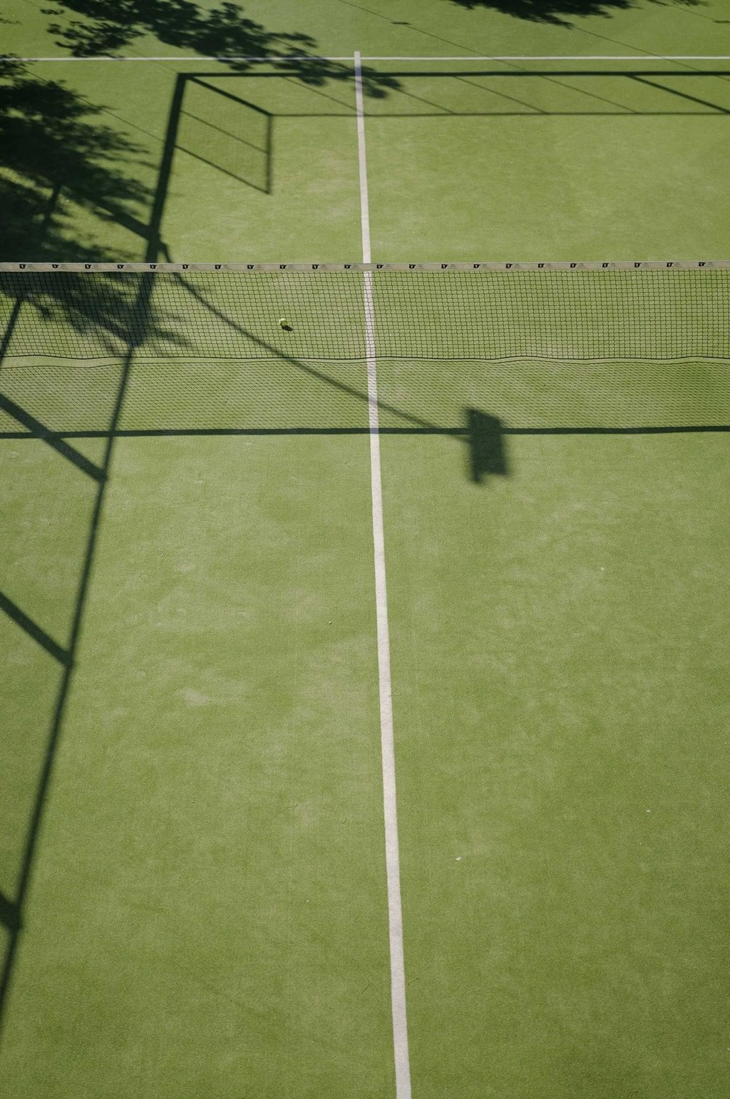 Private padel tennis court with net and green surface