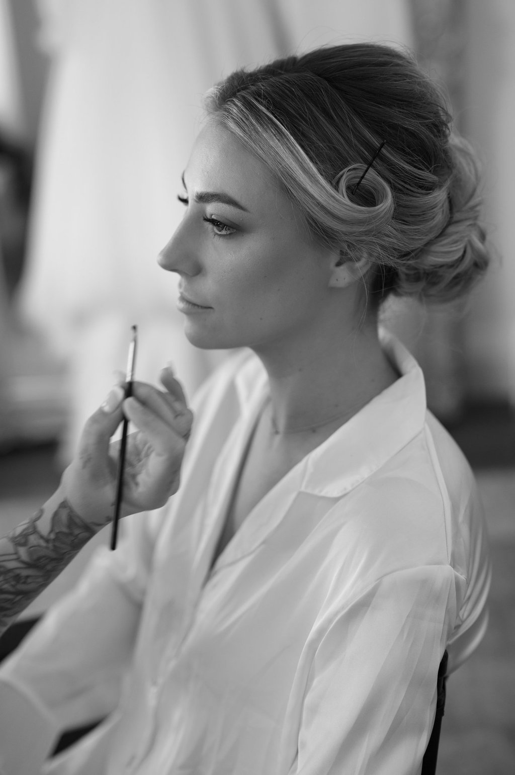 a woman getting makeup done by a professional makeup artist