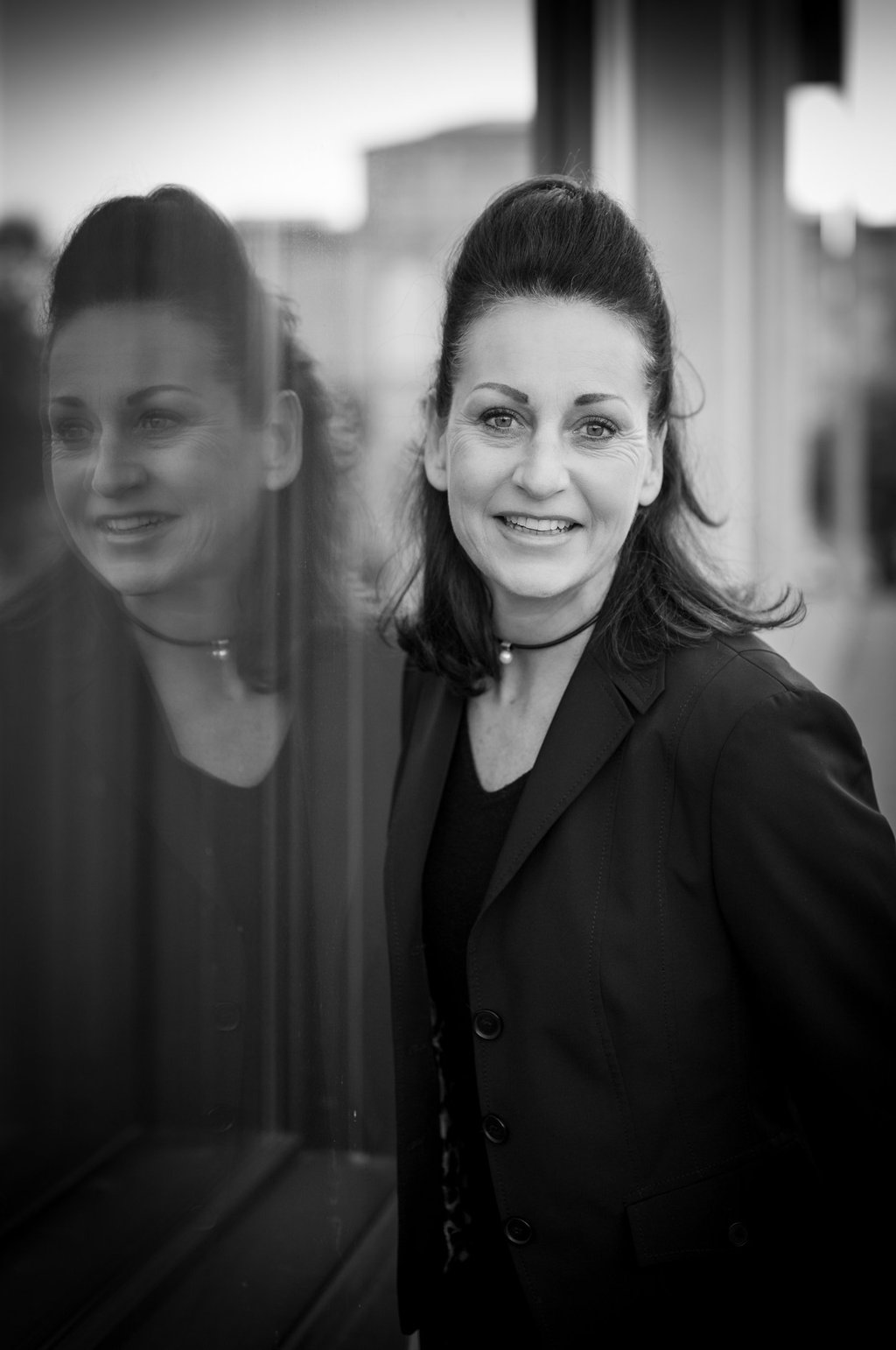 a woman in a black jacket and glasses