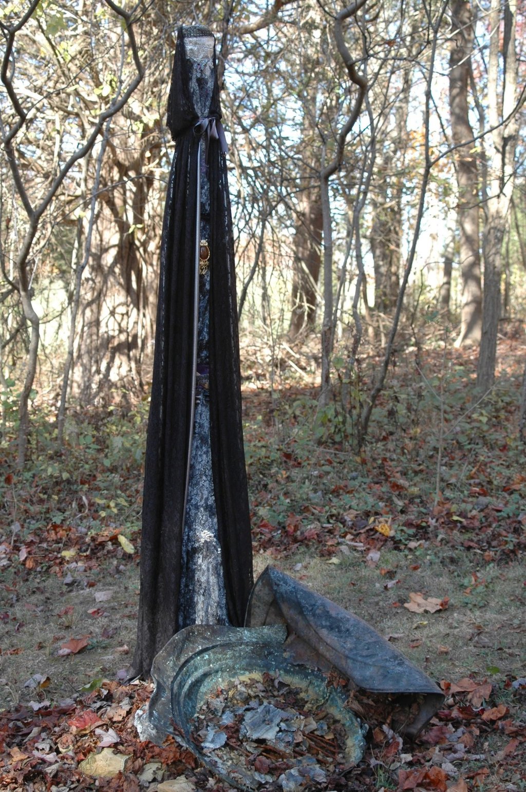 Pole draped in black fabric standing in the woods