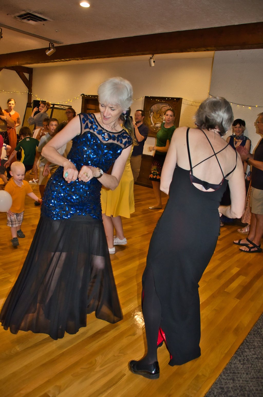 a woman in a blue dress dancing with a woman in a black dress