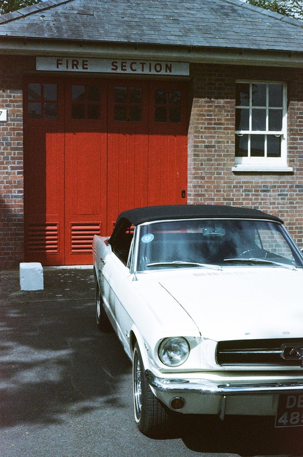 a classic Ford Mustang parked in front of a brick building