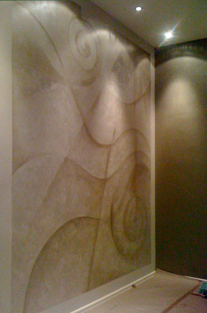 A room with abstract mural in silver paint featuring lines and wavy curves.
