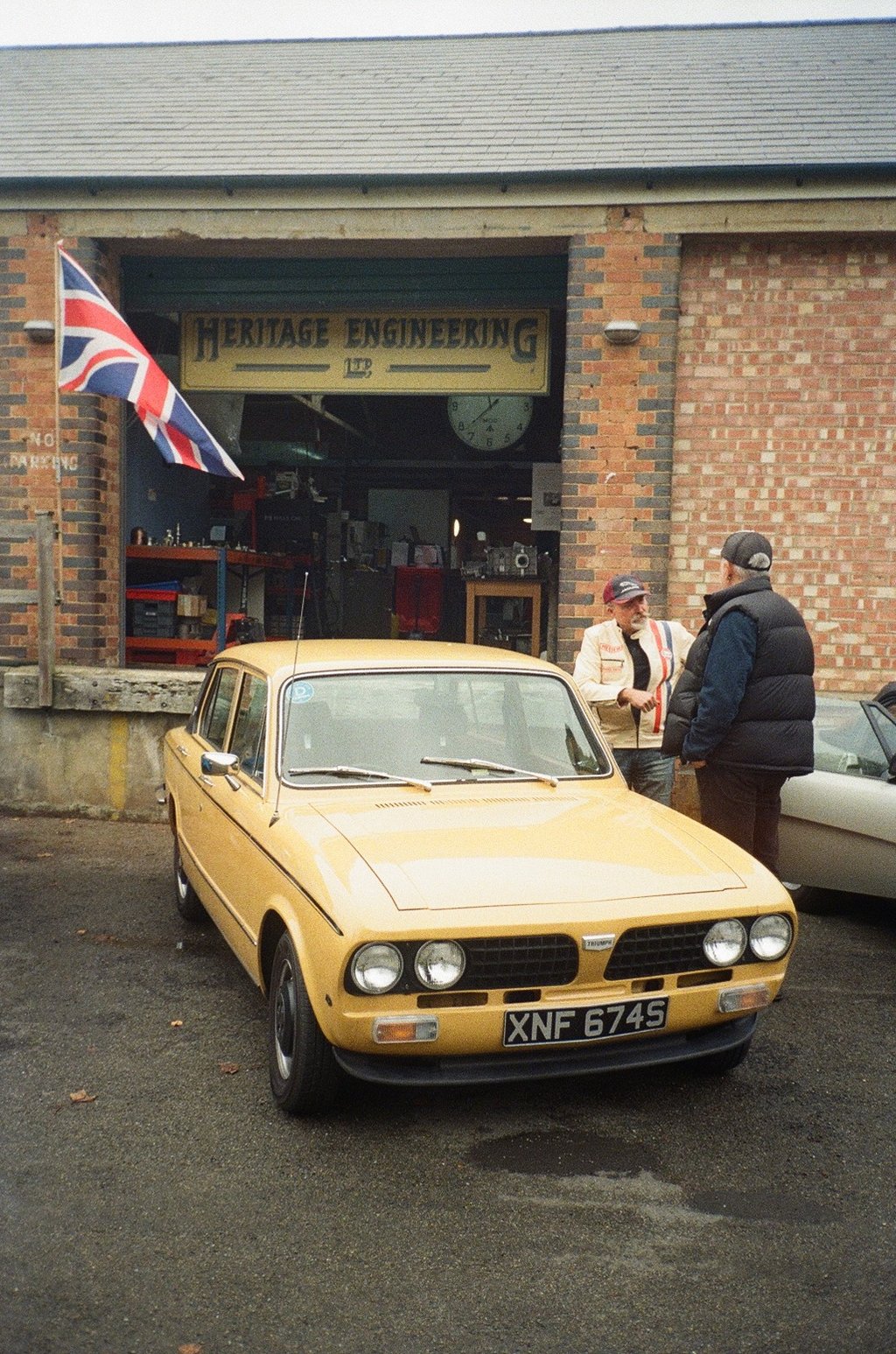 a yellow car parked in front of a brick building