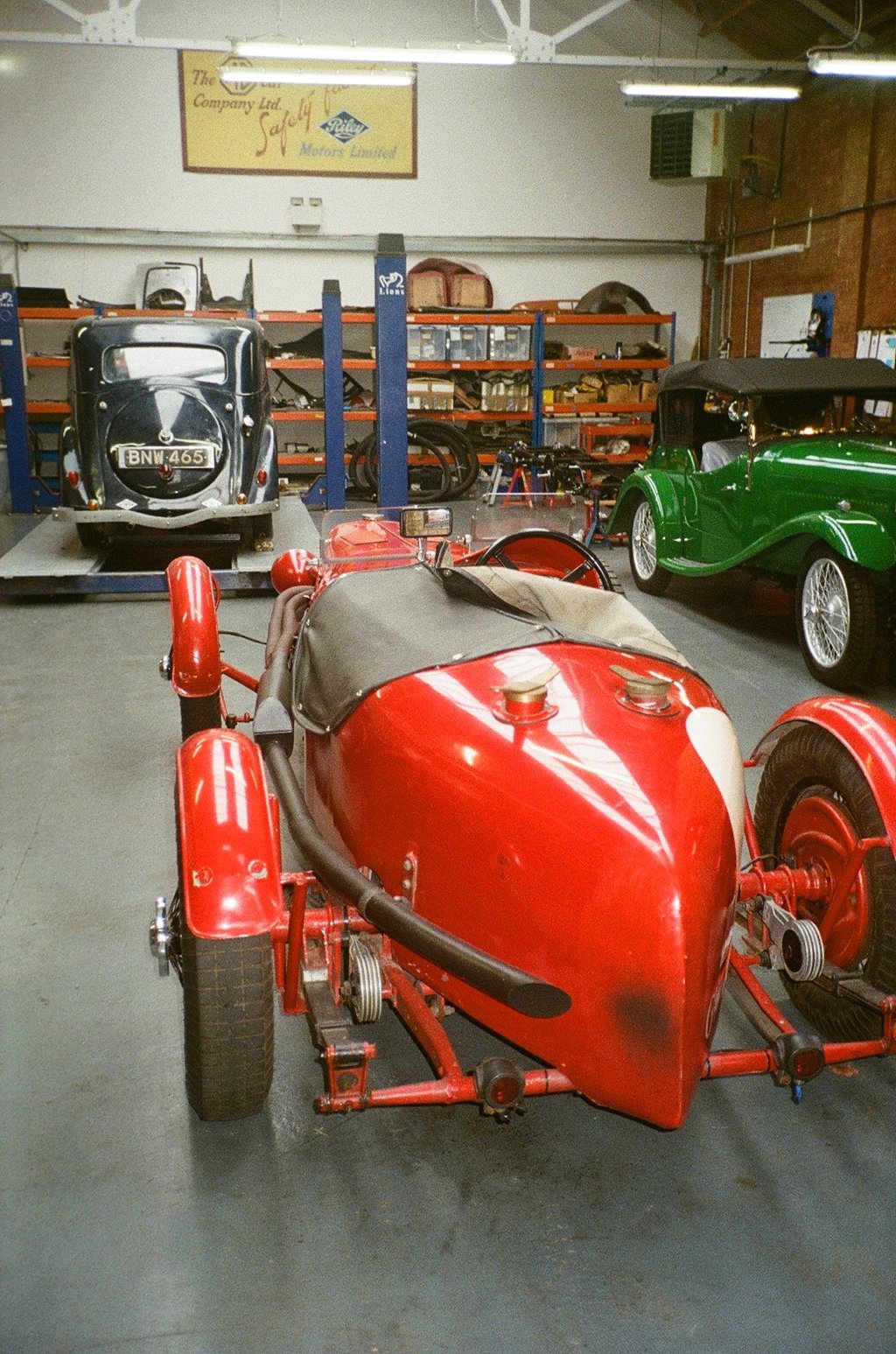 a classic car garage with three vintage cars parked in it