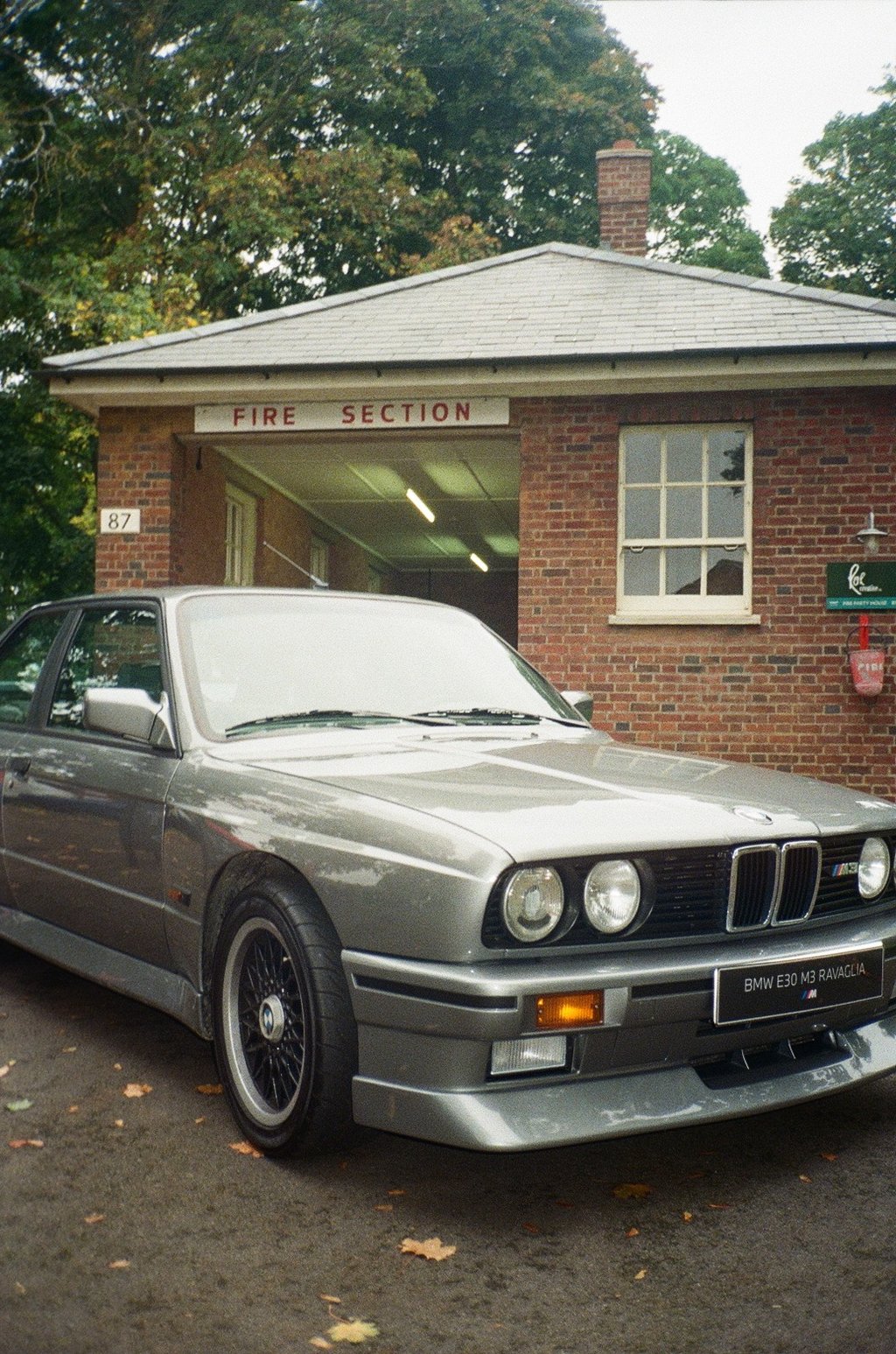 a classic BMW parked in front of a brick building