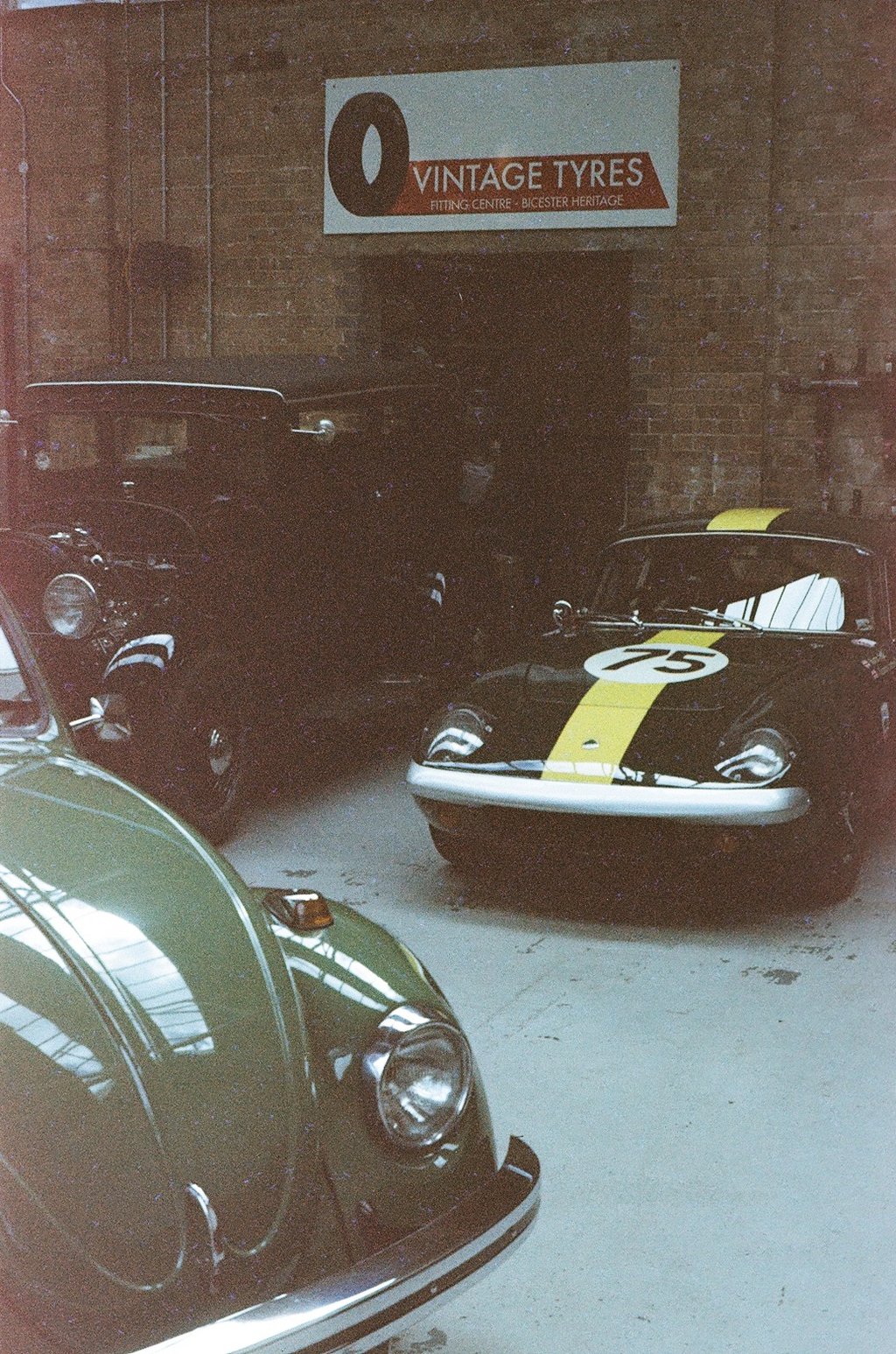 a classic car garage with three vintage cars parked in it