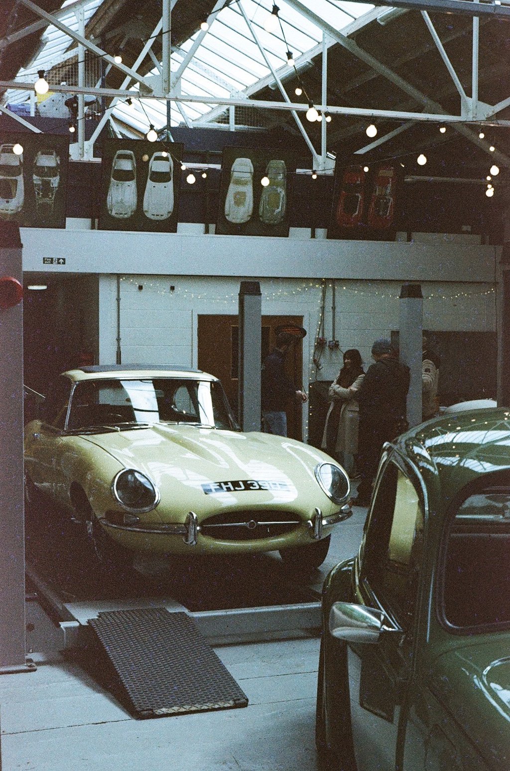 a classic car garage with two vintage cars parked in it