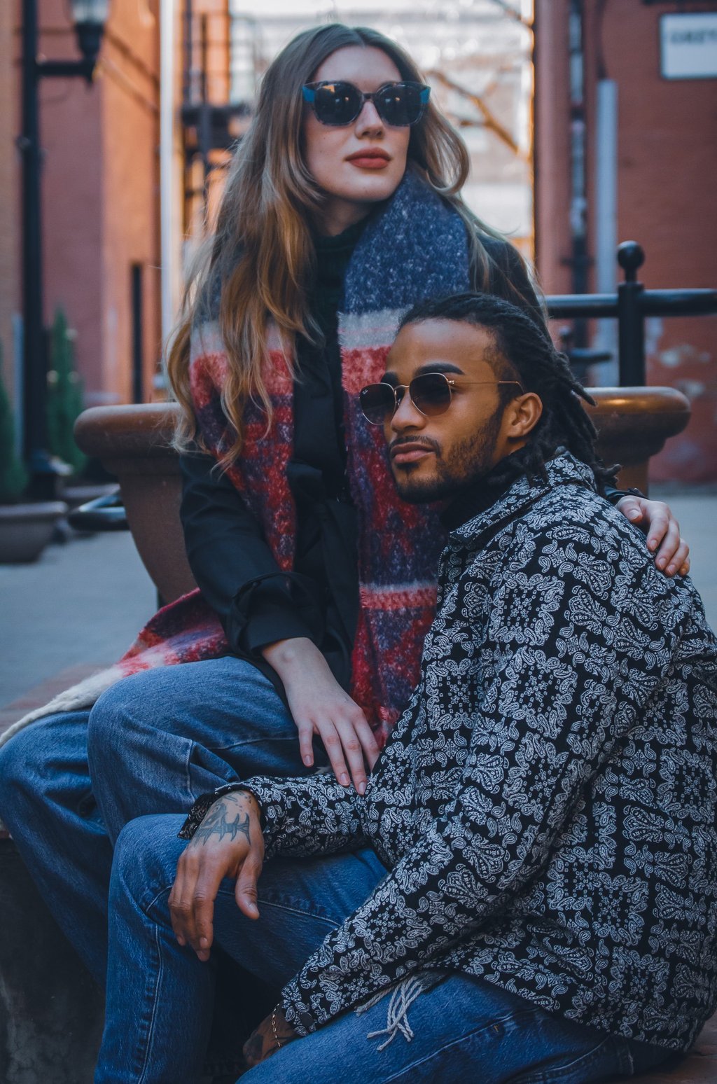 Two young adults wearing fashion sunglasses in an alley of Fort Collins, Colorado
