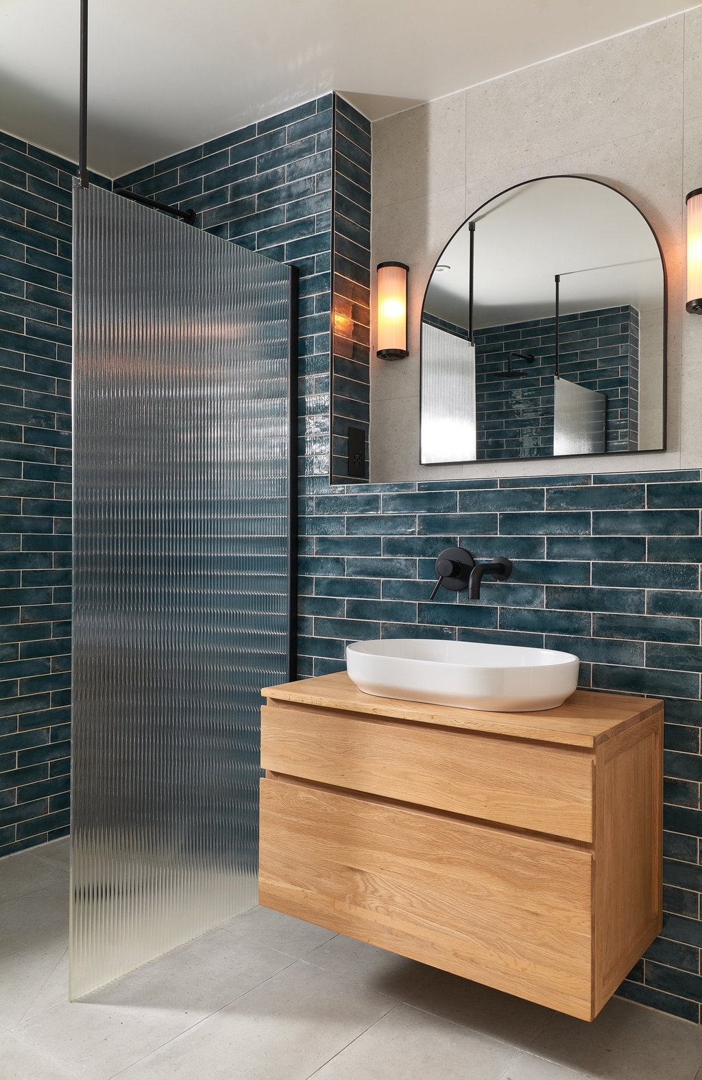 deep, glossy teal metro tiles, laid in a horizontal stack with white grout and oak floating vanity