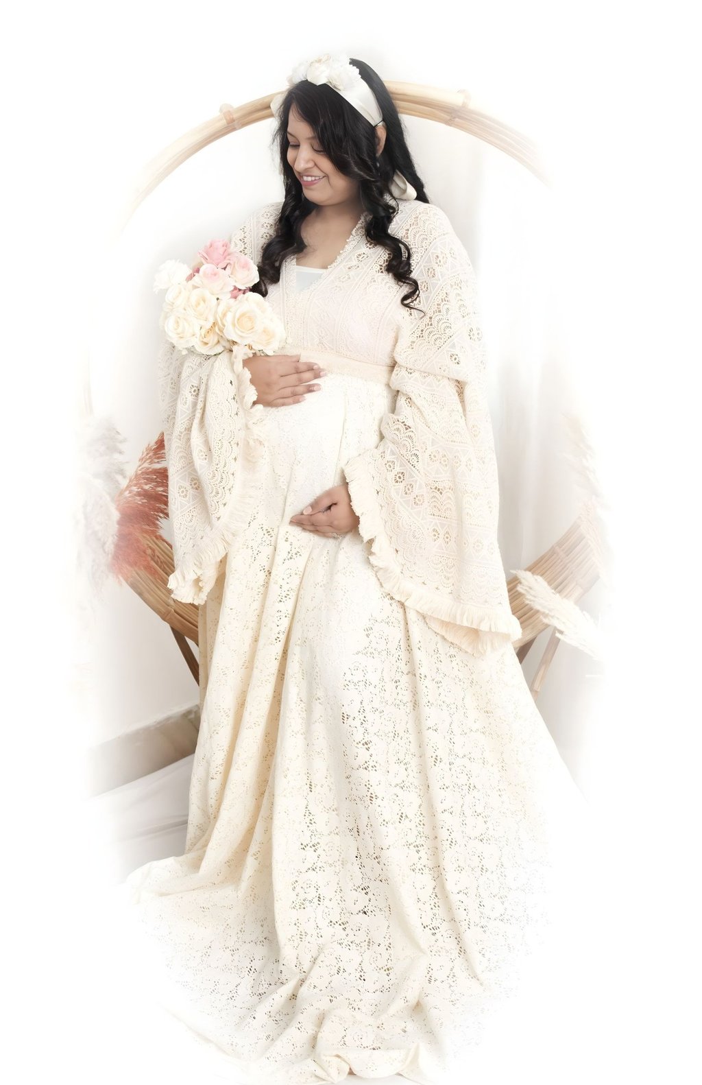 pregnant woman highlighting her baby bump against a studio backdrop.