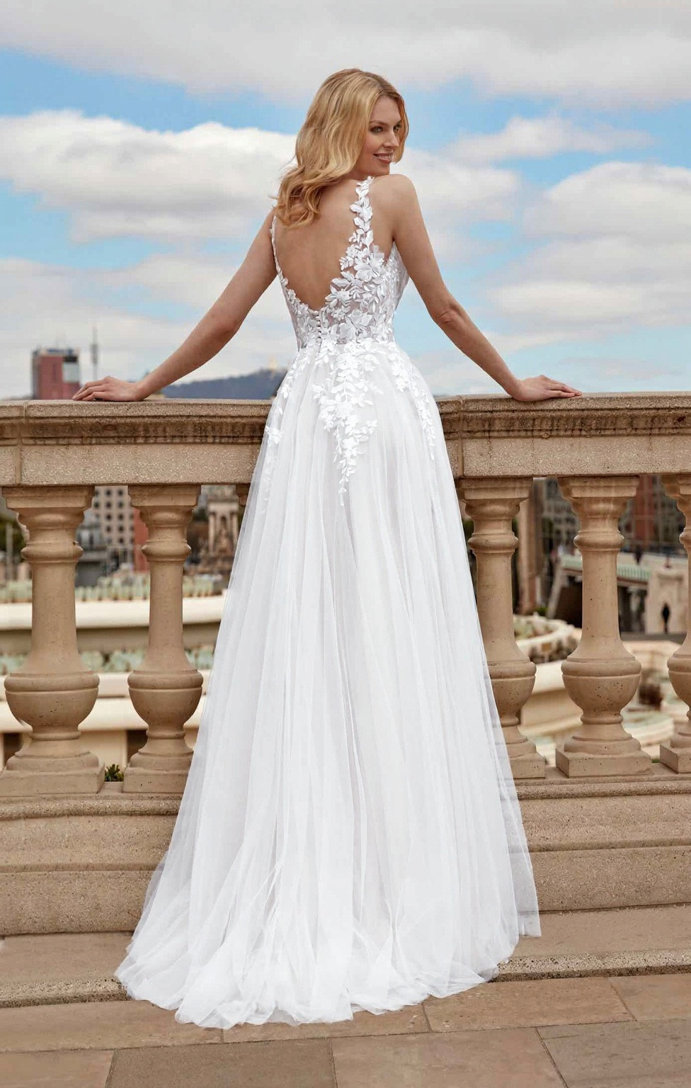 a woman in a white dress standing on a balcony