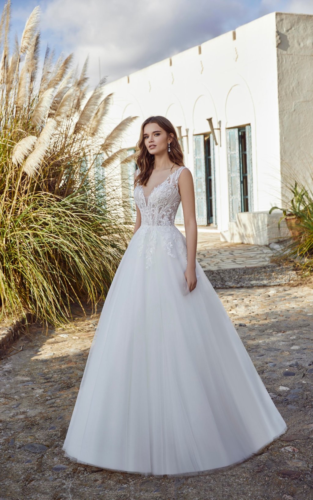 a woman in a white wedding dress standing in front of a house