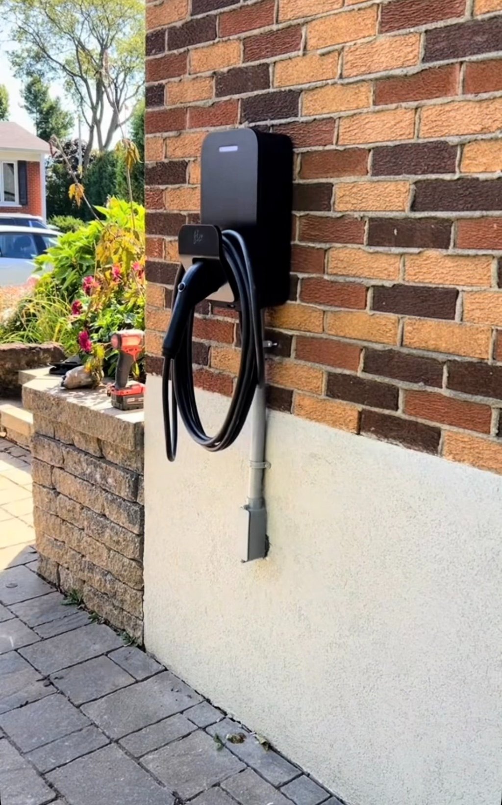 Installation d'une borne FLO sur une maison en brique.