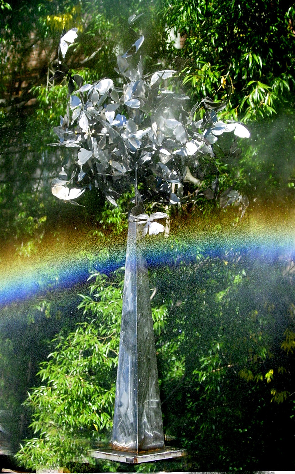 sculpture of a chrome pyramid with a ball of butterflies on top